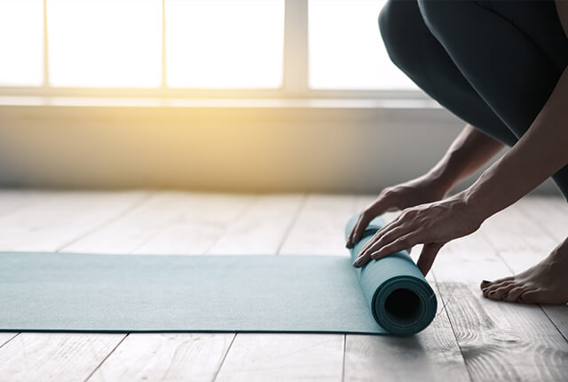 A photo of a woman unrolling an exercise mat