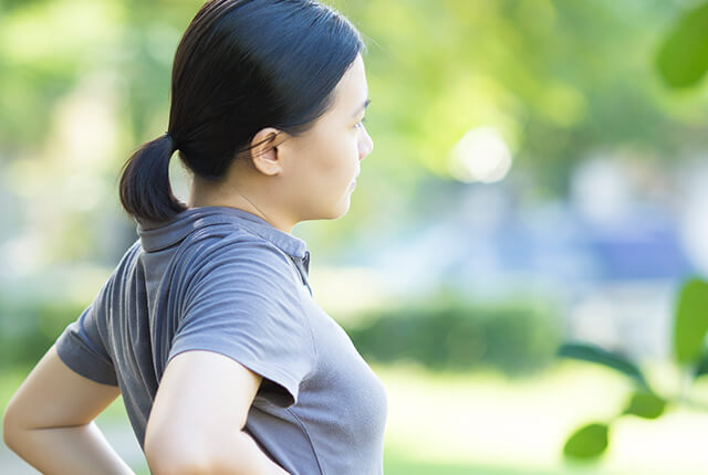 Photo of a woman stretching in a sunny outdoor setting