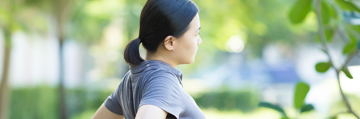 Photo of a woman stretching in a sunny outdoor setting
